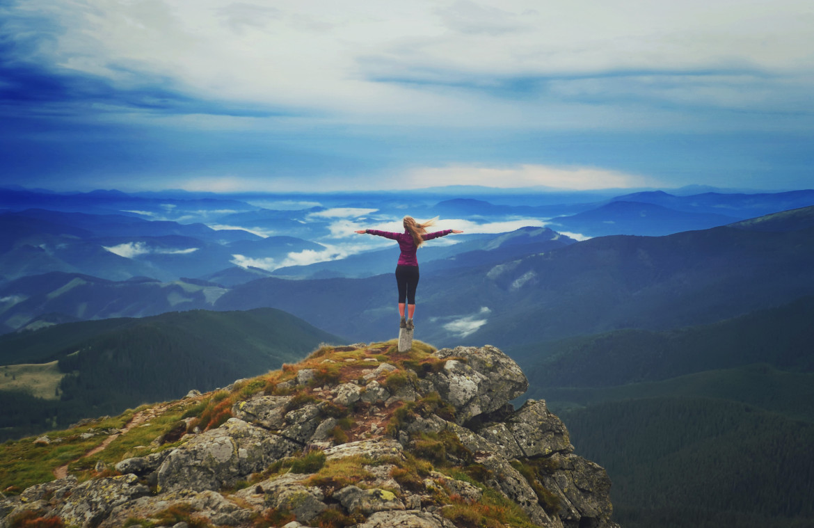 young-woman-on-a-stone-with-raised-hands.jpg